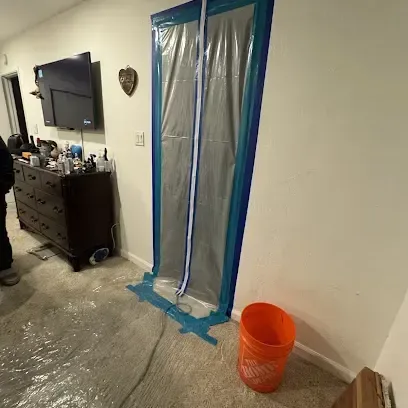Zippered plastic containment doorway set up to hold dry air in a work area